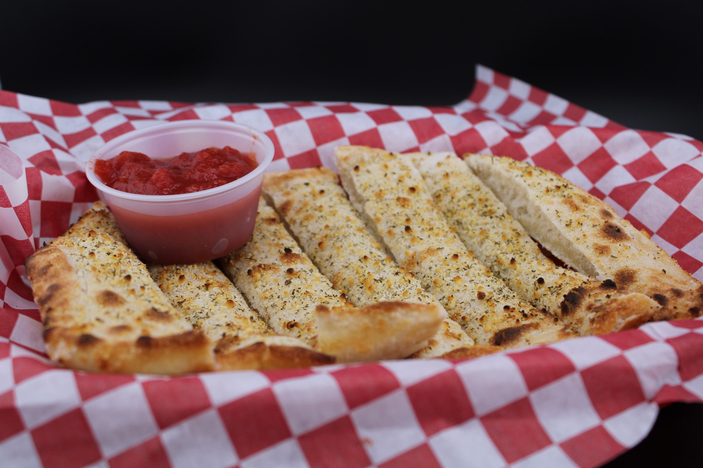 Pizza sides with breadsticks, salad, and drinks from Pizza Meltdown